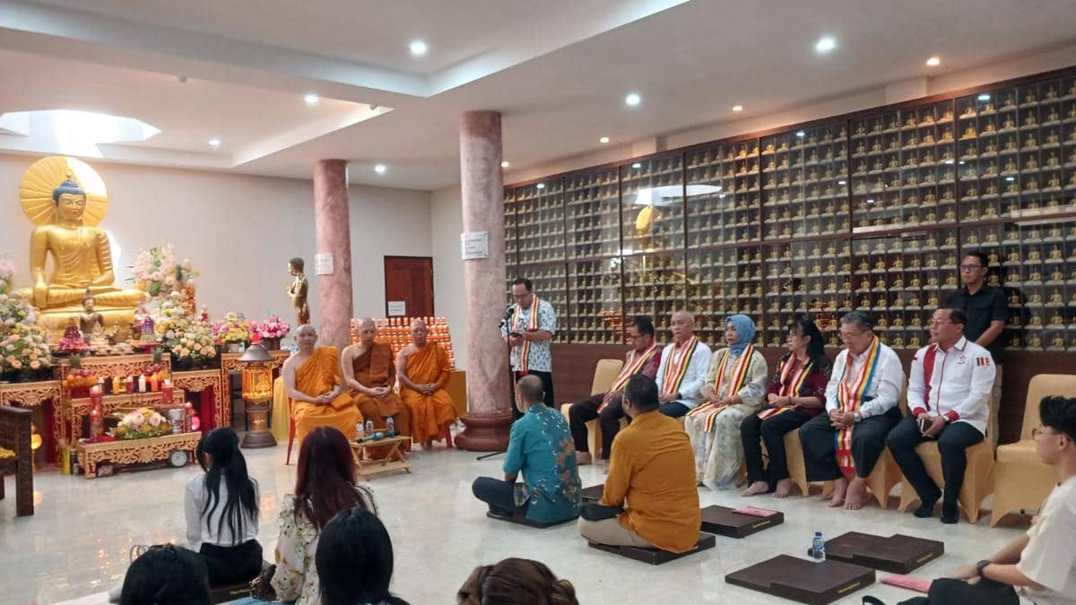 Umat Buddha dan biksu mengikuti ibadah Tri Suci Waisak di Vihara Dhammadipa Manado dengan latar patung Buddha dan hiasan bunga.
