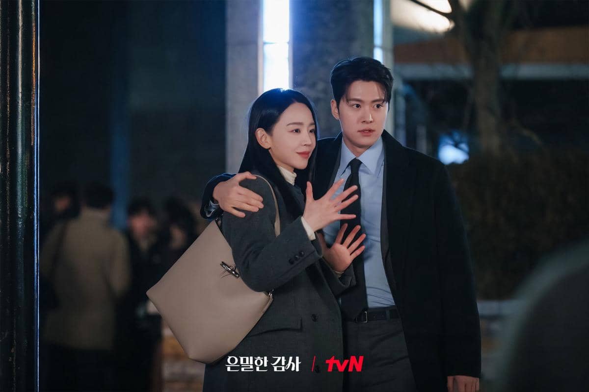 Dua pemeran utama drama Korea Filing for Love berdiri bersama di malam hari, saling berpelukan dengan ekspresi hangat.