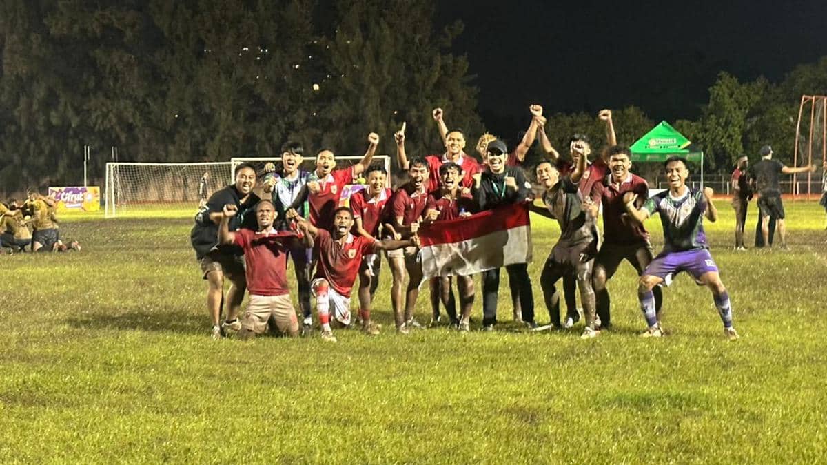 Tim sepak bola Indonesia merayakan kemenangan di lapangan malam hari sambil memegang bendera merah putih setelah lolos ke final IFA7 World Championship 2026.