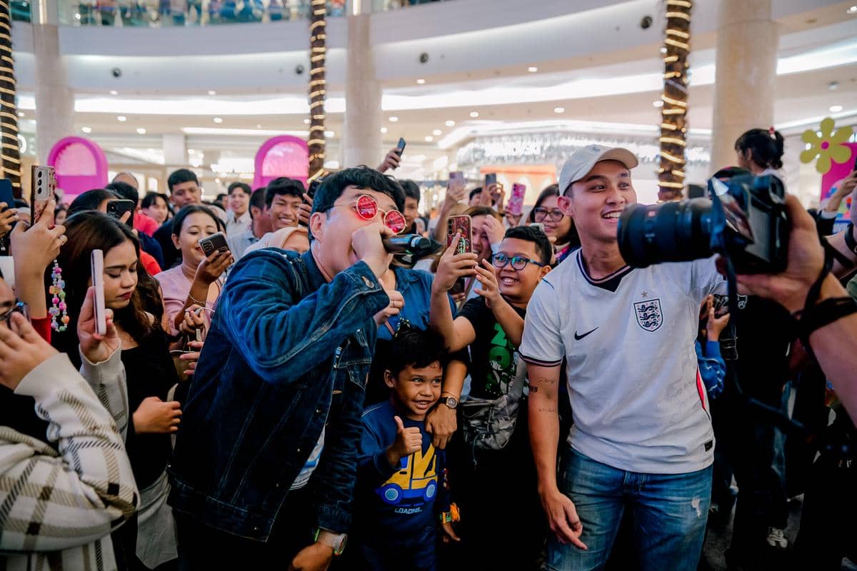 Seorang penyanyi tampil di tengah kerumunan penggemar yang antusias sambil memegang mikrofon di acara BeautyFest Asia Jakarta 2026.
