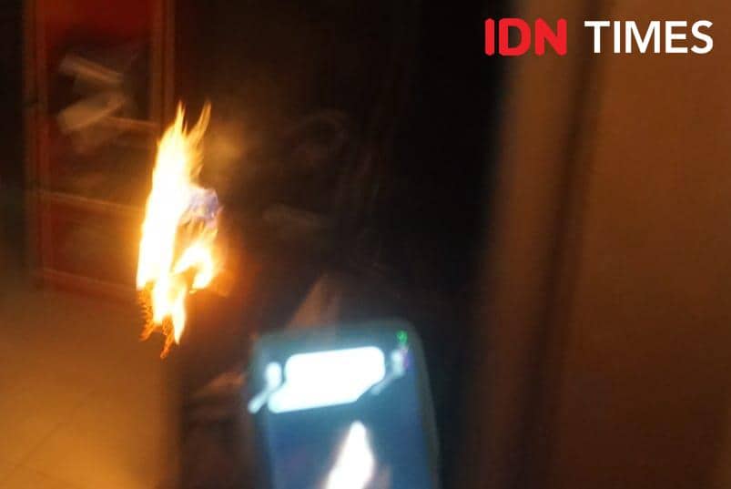 Api misterius membakar barang di dalam rumah warga Seyegan, Sleman, dengan nyala api terlihat jelas di ruangan gelap.