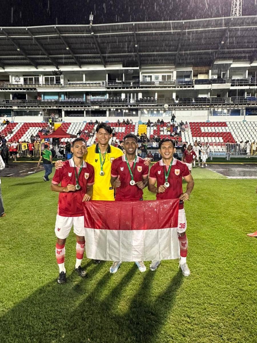Empat pemain tim Indonesia memegang bendera Merah Putih di stadion setelah meraih posisi runner up IFA7 World Championship 2026.