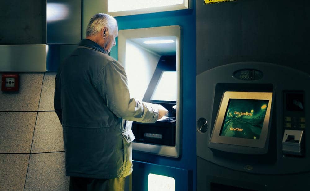 ilustrasi seorang pria sedang menarik uang di mesin ATM
