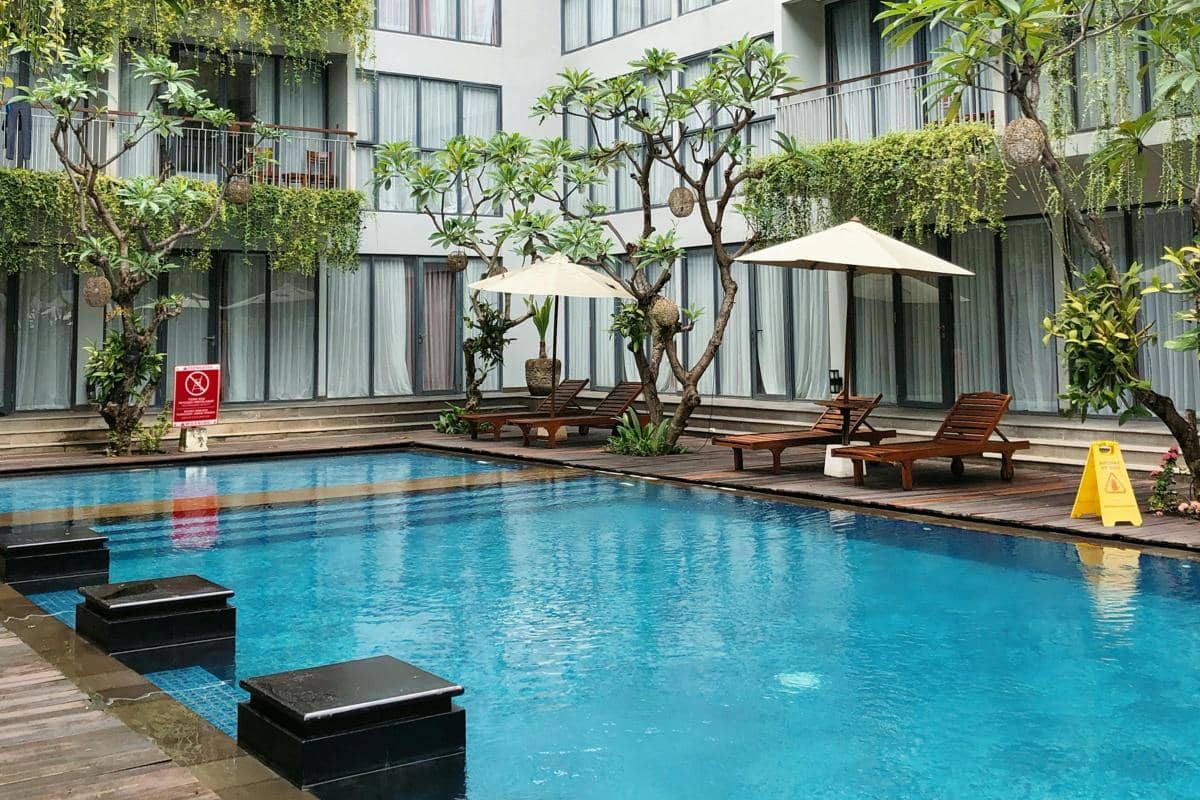 Ilustrasi area kolam renang hotel dengan suasana santai untuk liburan singkat di tengah kota.