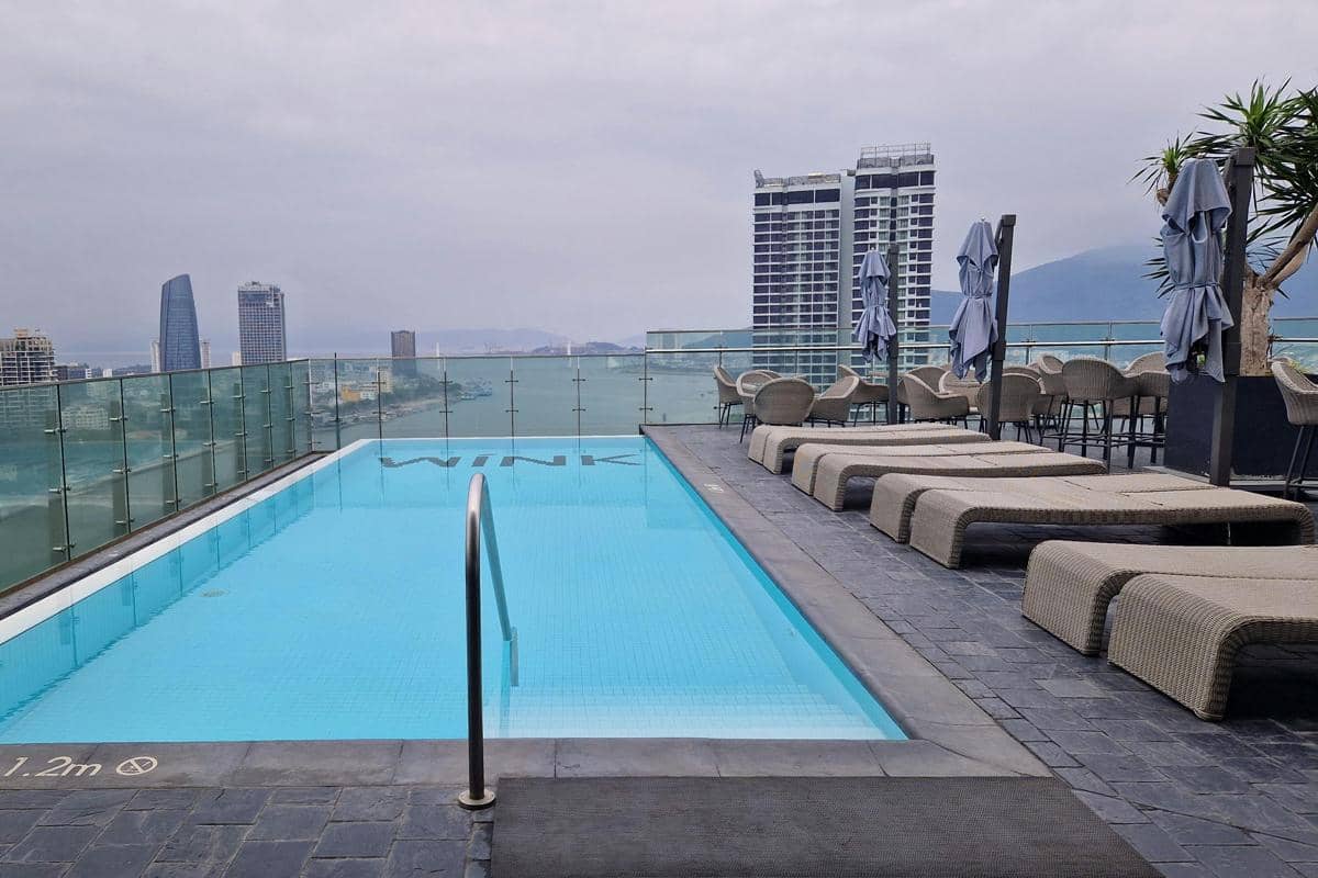 Ilustrasi kolam renang rooftop hotel dengan pemandangan Kota Surabaya dari ketinggian.