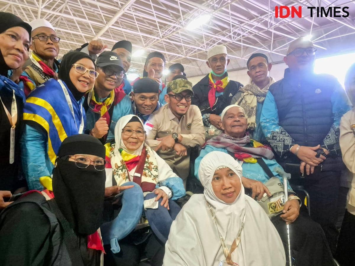 Seorang pejabat Kementerian Haji dan Umrah berfoto bersama jemaah haji asal embarkasi BTH 02 sebelum keberangkatan pulang ke Indonesia.