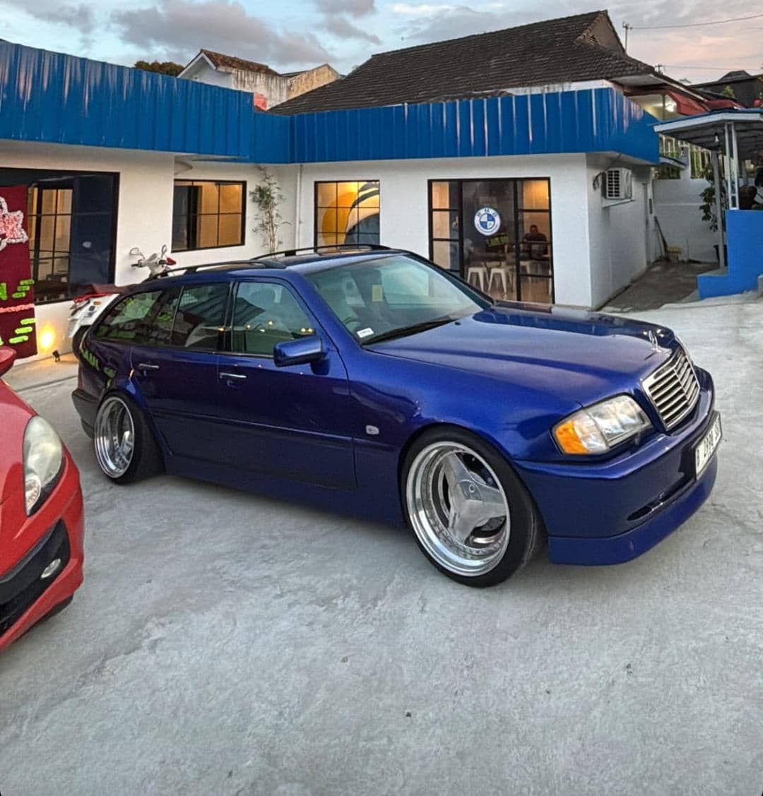 Mobil station wagon berwarna biru tua dengan bodi rendah terparkir di depan bangunan putih bernuansa biru bernama Bahagia Canteen.