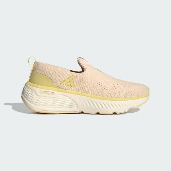 Sepatu slip-on Cloudfoam Go Lounger berwarna krem dengan sol tebal putih dan detail kuning muda di bagian tumit.
