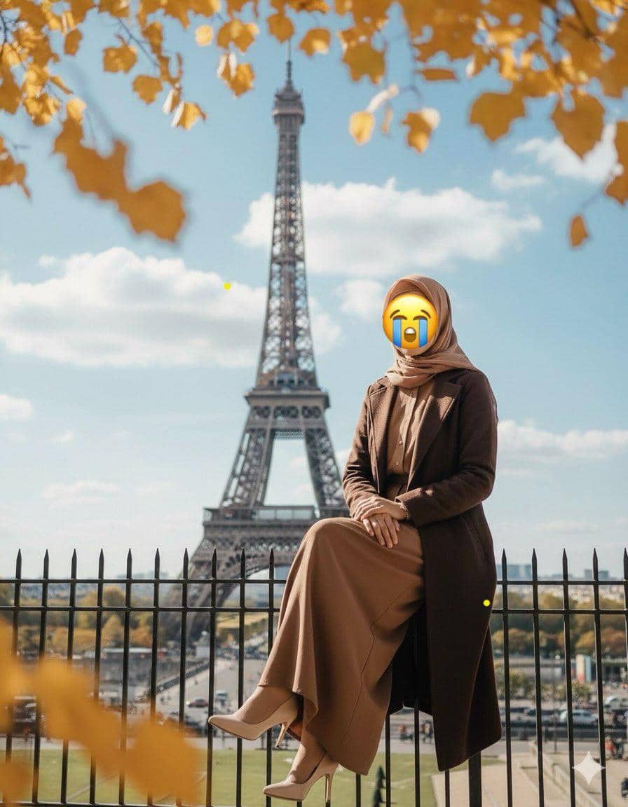 Seorang perempuan berhijab duduk di pagar dengan latar belakang Menara Eiffel di Paris, dikelilingi daun kuning musim gugur.