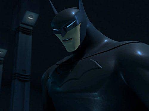 Batman versi animasi dengan kostum hitam dan topeng khas sedang berdiri di ruangan gelap dalam serial Beware the Batman.