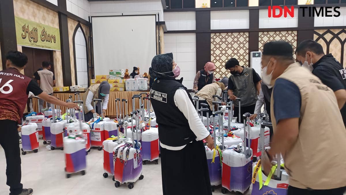 Petugas di Asrama Haji Sudiang Makassar sedang merapikan koper jemaah haji Kloter 1 Debarkasi Makassar yang baru tiba pada malam hari.