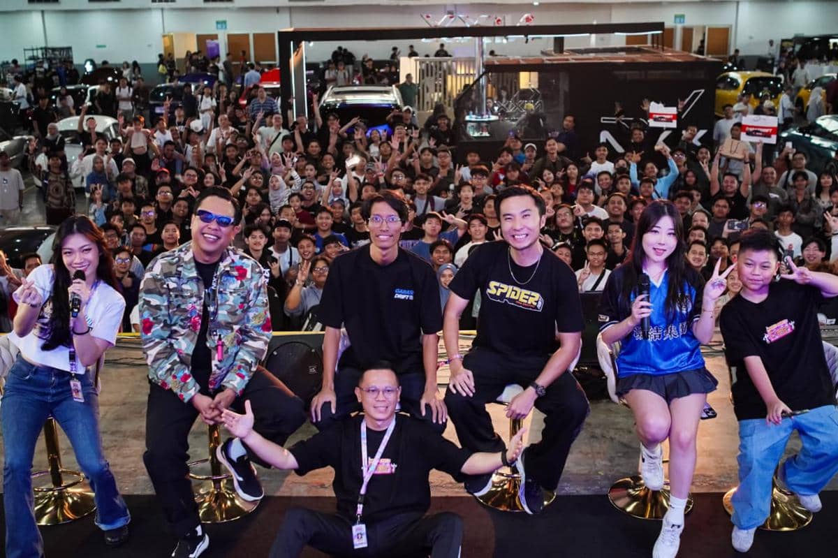 Sejumlah kreator nasional dan internasional berpose di atas panggung di depan kerumunan penonton dalam acara otomotif IMX.