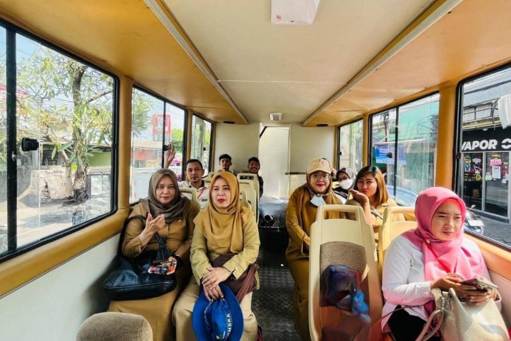 Interior bus wisata dengan area duduk yang nyaman untuk perjalanan wisata kota.