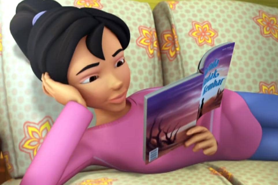 Kak Ros membaca buku Legenda Budak Kembar di kursi ruang tamu