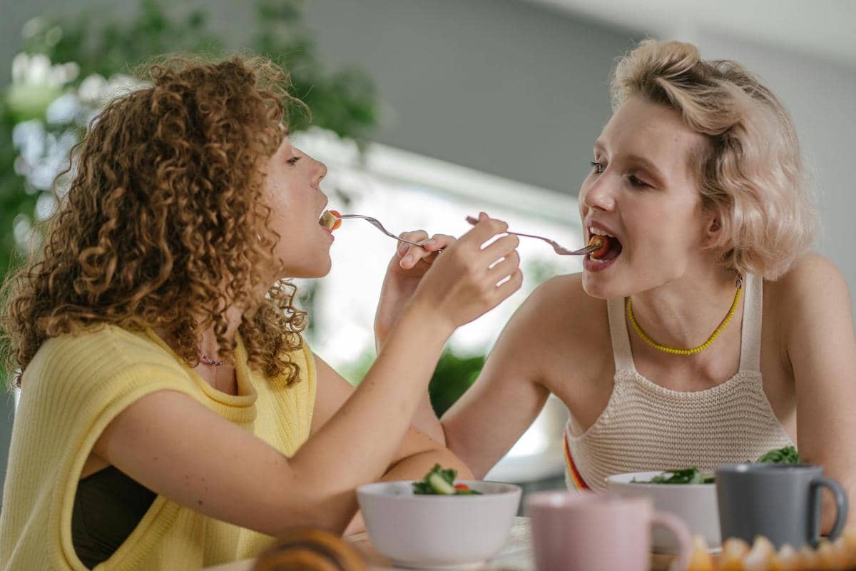 sahabat yang saling menyuapi makanan 