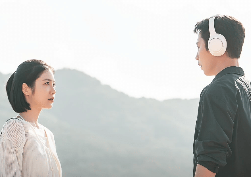 Dua karakter dalam drama Korea Doctor On The Edge berdiri saling berhadapan di luar ruangan dengan latar pegunungan berkabut.