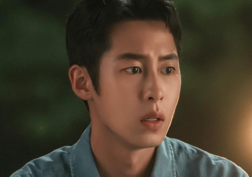 Seorang pria berwajah serius mengenakan kemeja biru dalam cuplikan drama Korea Doctor On The Edge.