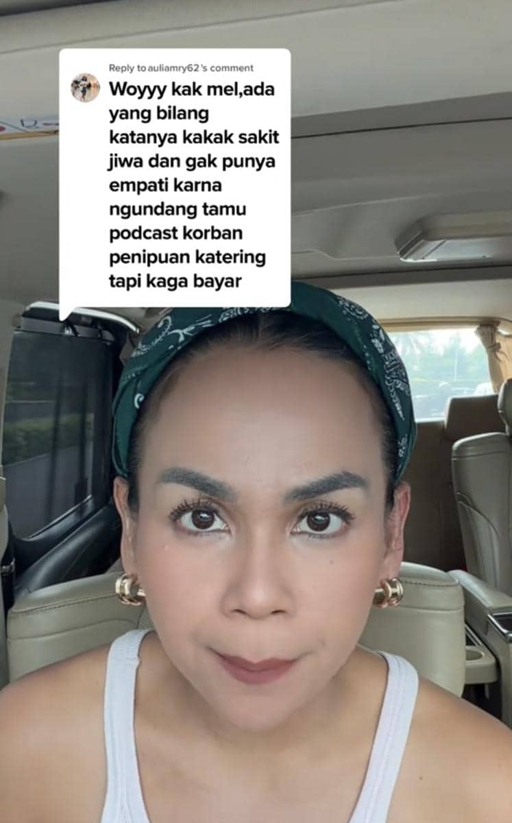 Seorang perempuan mengenakan bandana hijau dan tank top putih sedang merekam video klarifikasi di dalam mobil dengan ekspresi serius.