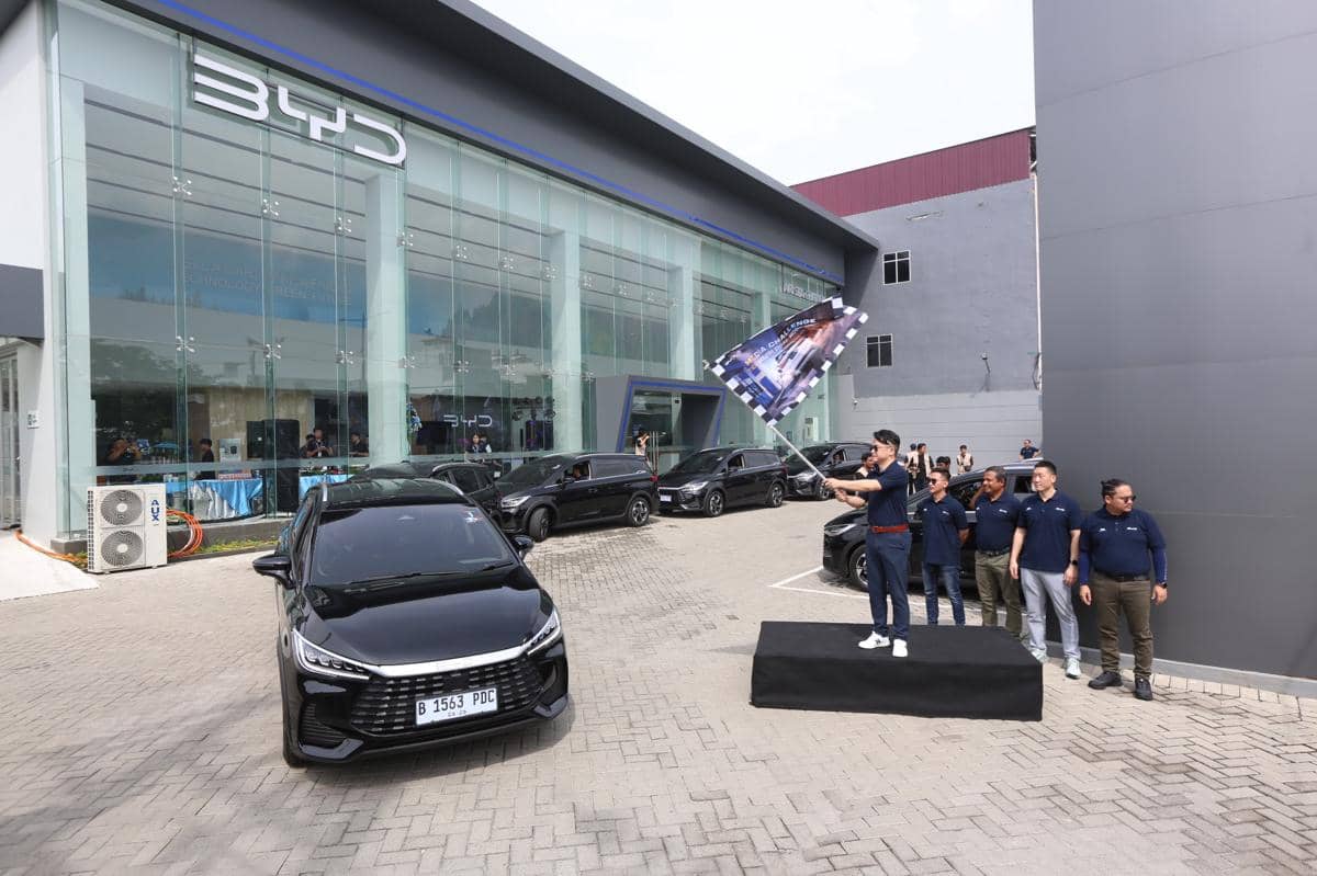 Mobil BYD DM 1 berwarna hitam bersiap memulai uji coba di depan gedung dealer BYD dengan beberapa orang berdiri di sampingnya.
