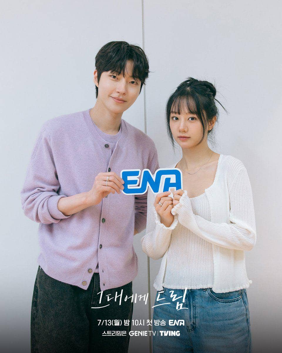 Dua pemeran utama drama Korea Dream to You berpose sambil memegang logo ENA saat pembacaan naskah di ruangan terang.