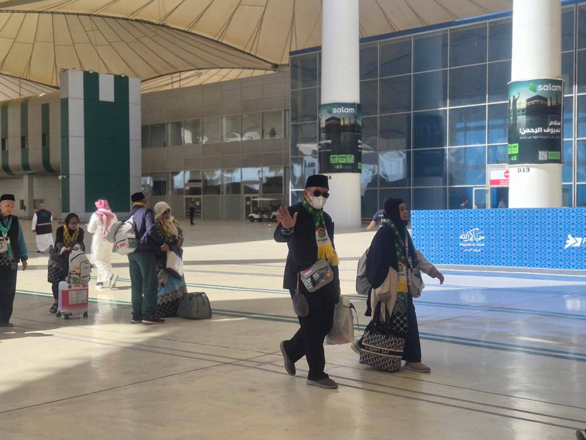 Jemaah haji Indonesia berjalan di Bandara Internasional King Abdulaziz Jeddah sambil membawa koper dan tas setelah menunaikan ibadah haji.