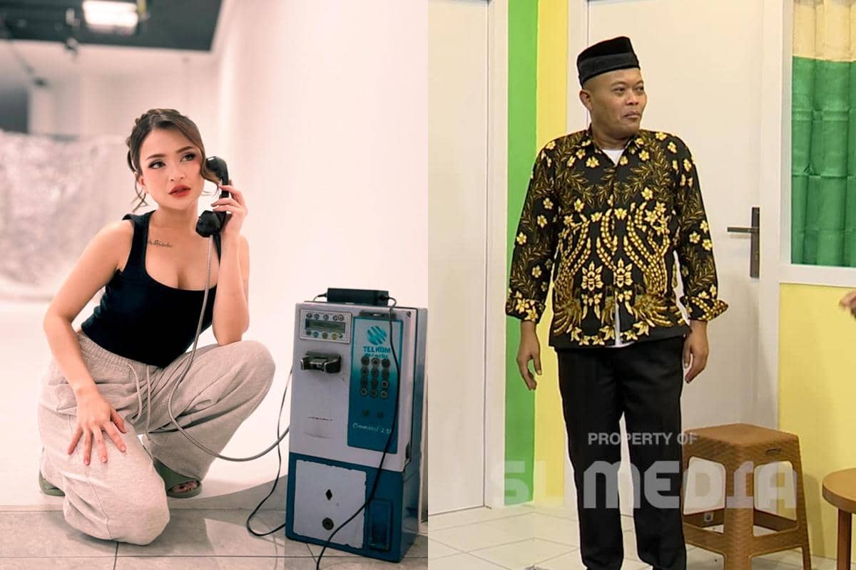 Seorang wanita berpose sambil memegang telepon umum di ruangan putih dan seorang pria mengenakan batik hitam emas berdiri di dalam ruangan.