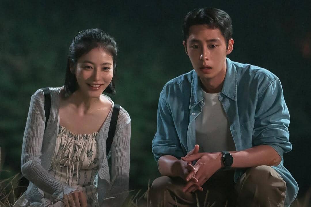 Dua karakter duduk berdampingan di luar ruangan pada malam hari dalam adegan drama Doctor on the Edge, dengan ekspresi serius dan hangat.
