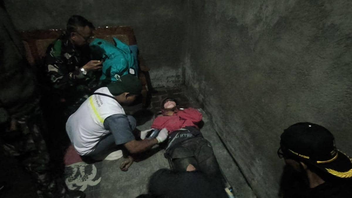 Tim SAR mengevakuasi seorang pendaki Gunung Semeru yang terbaring di lantai ruangan dengan kondisi lemah dan mendapat pertolongan pertama.