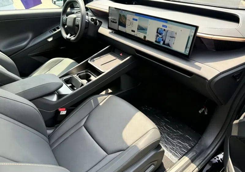 Interior Hyundai Ioniq V dengan desain modern, layar lebar di dasbor, dan jok kulit berwarna gelap yang tampak elegan.