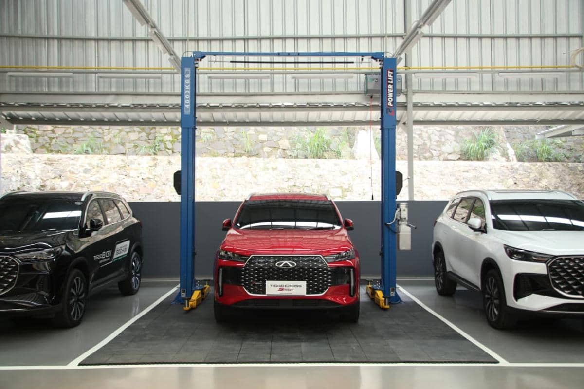 Tiga mobil SUV berwarna hitam, merah, dan putih berada di area bengkel dengan fasilitas lift hidrolik untuk layanan 3S.