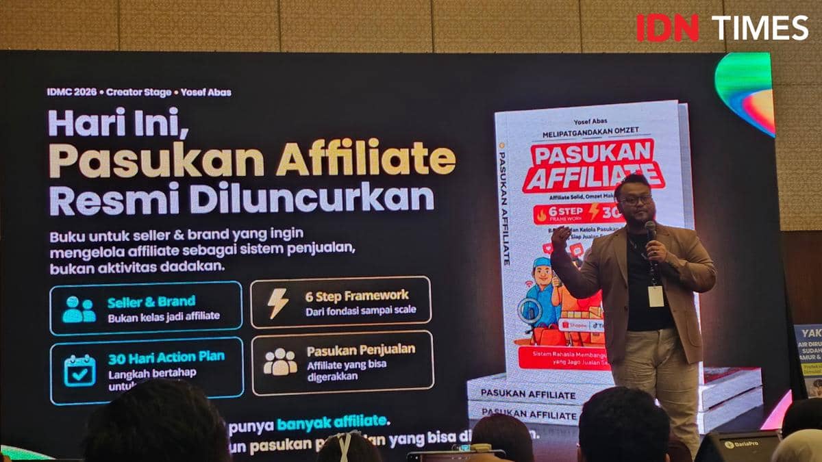 Seorang pembicara mempresentasikan peluncuran buku berjudul Pasukan Affiliate di atas panggung dengan layar besar menampilkan informasi acara.