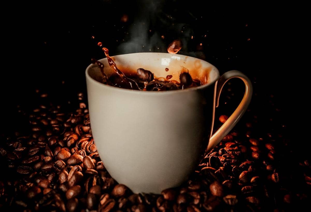ilustrasi secangkir kopi hitam dan biji kopi