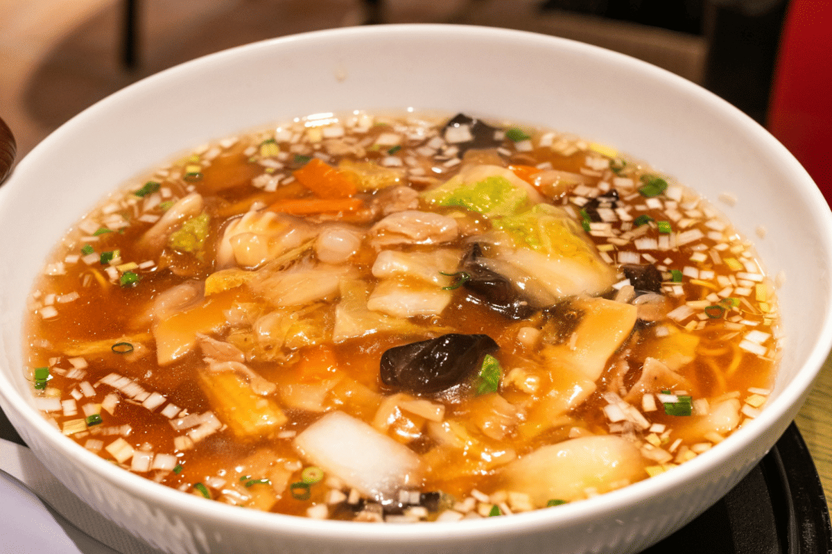 Semangkuk sup diet Korea berisi sayuran seperti wortel, kubis, dan jamur dalam kuah bening hangat yang menggugah selera.