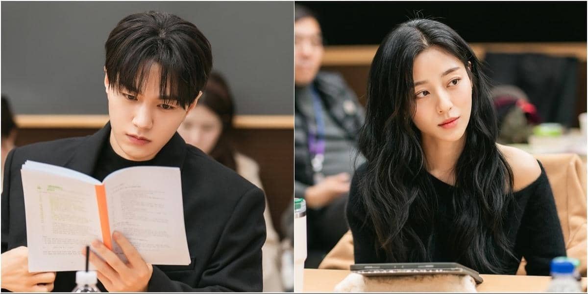 Dua aktor Korea sedang membaca dan mendiskusikan naskah drama Empathy Cells di ruang latihan dengan suasana serius dan fokus.