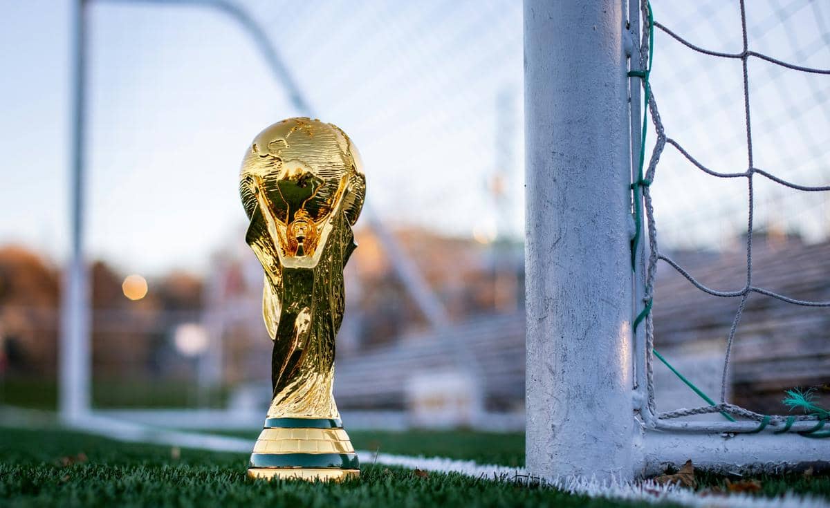 Trofi Piala Dunia berada di dekat gawang lapangan sepak bola.