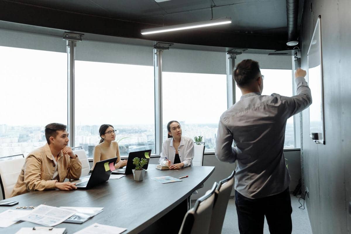 Ilustrasi seorang pemimpin mendelegasikan tugas kepada anggota tim dalam suasana kerja profesional di kantor.