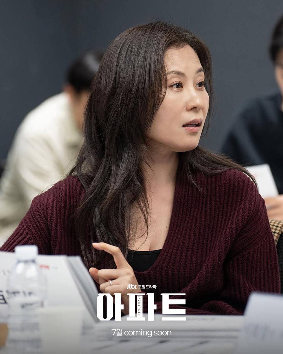 Seorang perempuan mengenakan sweater merah tua sedang berbicara saat pembacaan naskah drama Apartement produksi JTBC.
