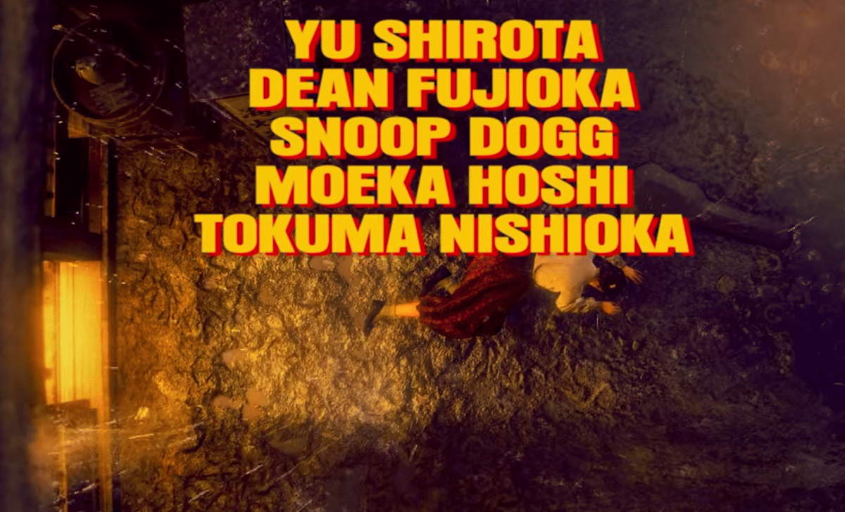 Teks nama pemeran Yu Shirota, Dean Fujioka, Snoop Dogg, Moeka Hoshi, dan Tokuma Nishioka dengan latar bernuansa gelap keemasan.