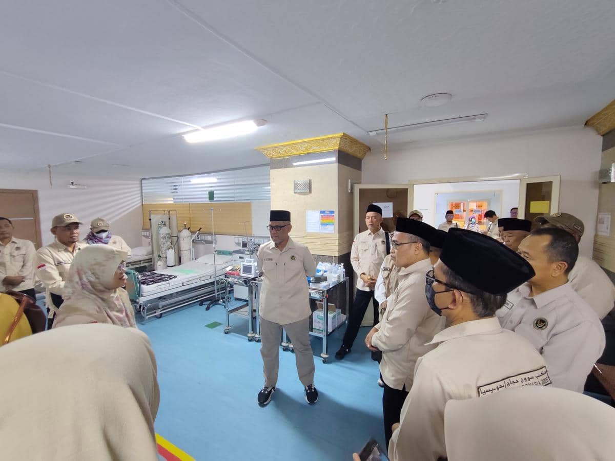 Sejumlah pejabat mengenakan seragam krem melakukan kunjungan ke ruang perawatan di Klinik Kesehatan Haji Indonesia, berdiskusi dengan petugas medis.