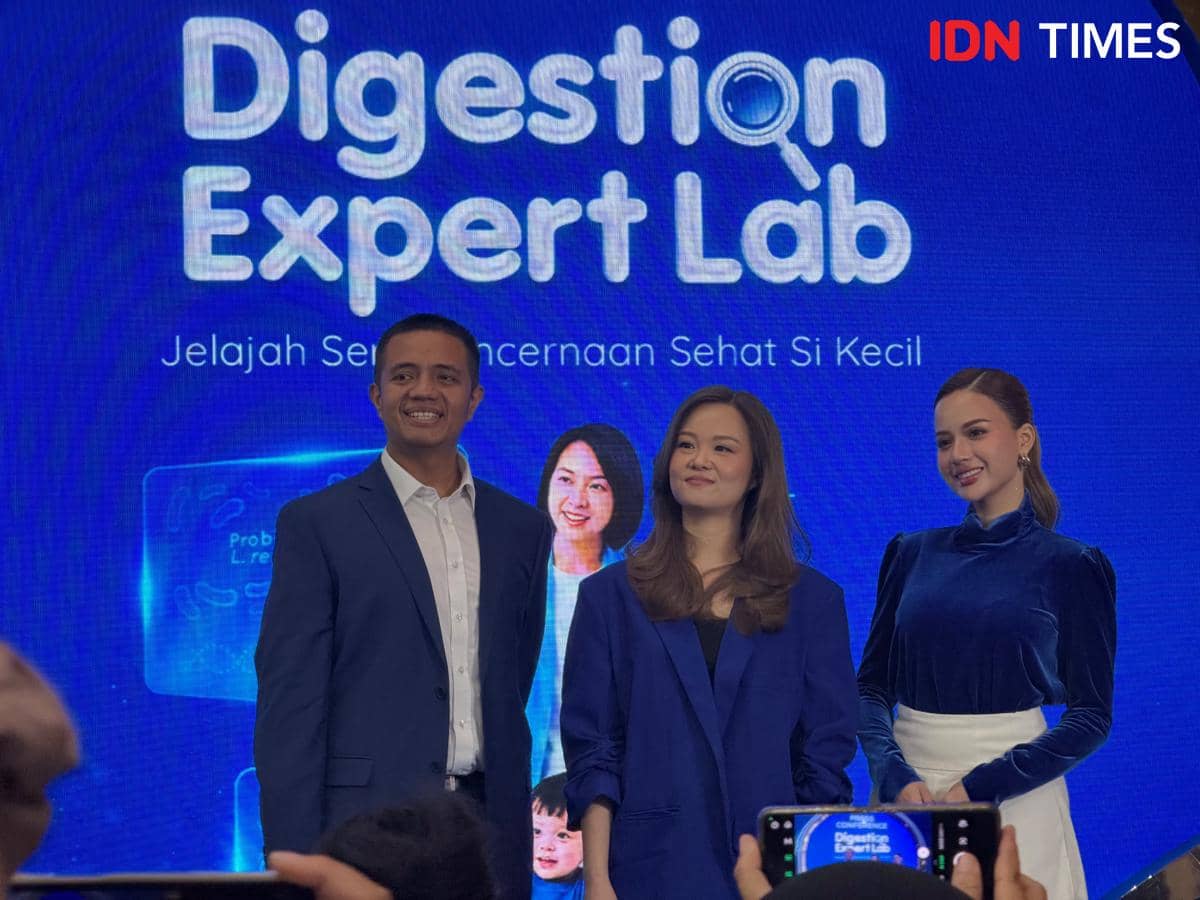 Tiga orang berpose di depan layar biru bertuliskan Digestion Expert Lab saat peluncuran LACTOGROW di Jakarta pada 5 Juni 2026.
