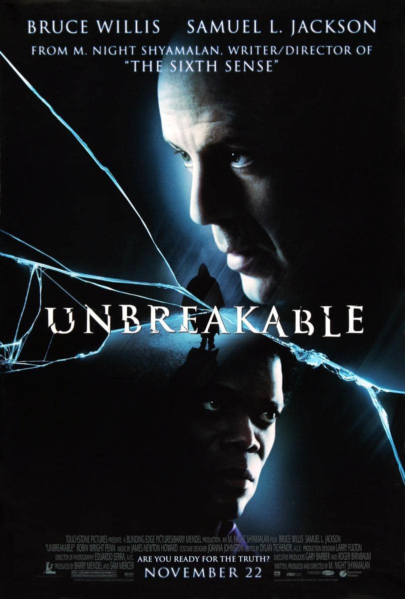 Poster film Unbreakable menampilkan dua wajah karakter utama dengan latar retakan kaca dan nuansa biru gelap yang misterius.
