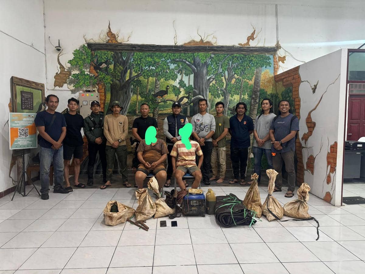 Tim gabungan TNBNW dan Polres Kotamobagu berfoto bersama dua pekerja PETI yang ditangkap beserta barang bukti di dalam ruangan.