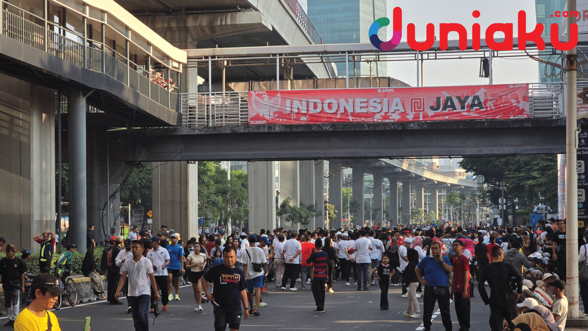 Keramaian warga mengikuti Car Free Day di Jalan Rasuna Said, Jakarta, dengan spanduk merah bertuliskan Indonesia Jaya di atas jalan layang.