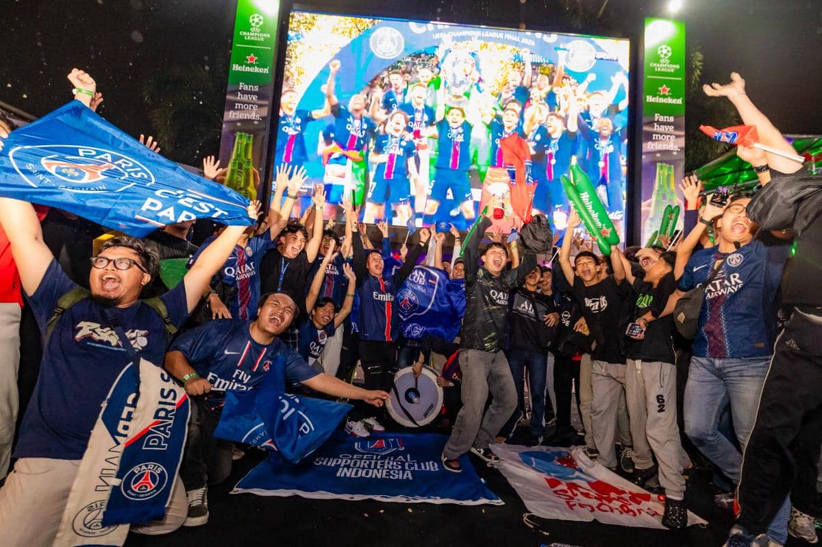 Suporter sepak bola bersorak dan mengibarkan bendera klub saat acara nonton bareng final Liga Champions 2025/26 yang diselenggarakan Heineken.