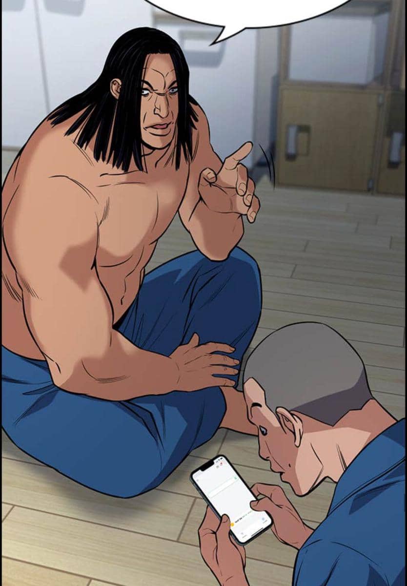 Dua karakter pria dari webtoon The Real Lesson duduk di lantai, satu tanpa baju berbicara sementara yang lain melihat layar ponsel.