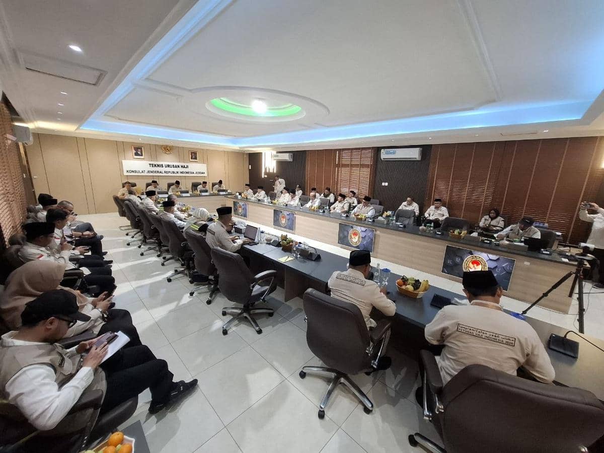 Suasana rapat Exit Meeting antara Amirul Hajj, BPIH, dan KJRI Jeddah di Kantor Urusan Haji dengan peserta duduk melingkar di ruang pertemuan modern.