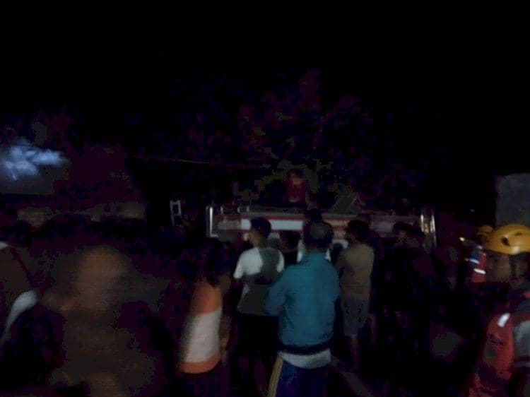 Sejumlah warga dan petugas pemadam kebakaran berkumpul di lokasi kebakaran rumah pada malam hari di Kupang.