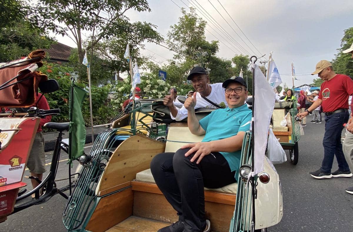 Peserta parade kendaraan nir emisi di Yogyakarta tersenyum dan berpose di atas becak saat acara Jogja Bersinar di Jalan Ipda Tut Harsono.