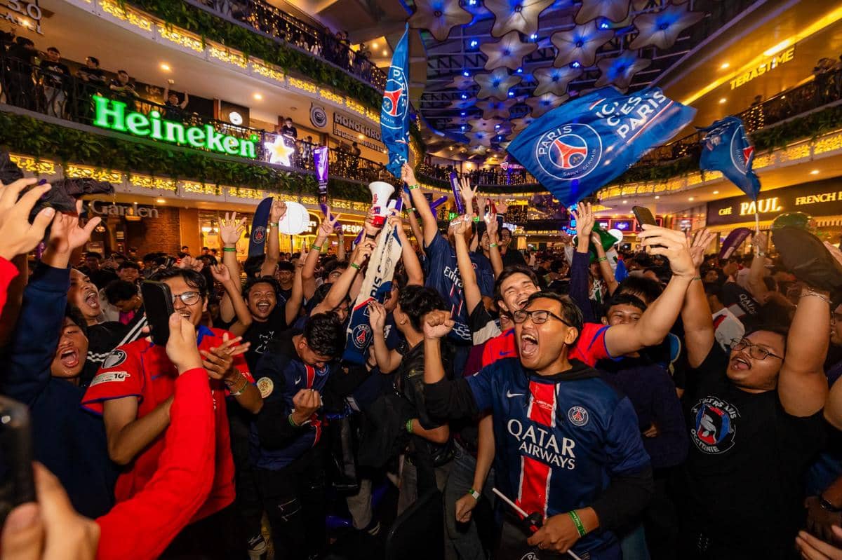 Suporter sepak bola bersorak dan mengibarkan bendera klub di acara nonton bareng final Liga Champions 2025/26 yang digelar Heineken.