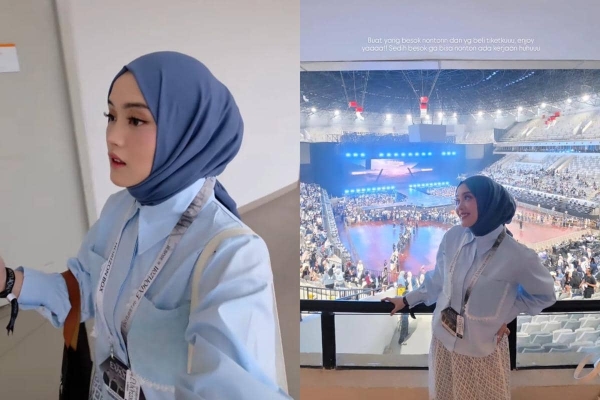 Seorang perempuan berhijab biru muda mengenakan kemeja biru dan lanyard konser berpose di area tribun konser EXO PLANET #6 di Jakarta.
